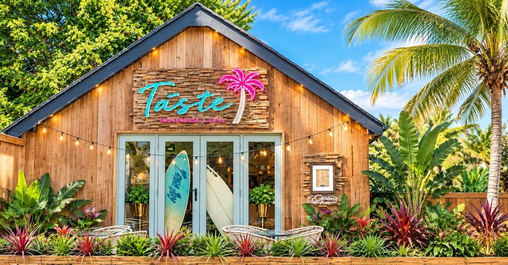 Taste Smokehouse storefront with new signage, surfboards and tropical planters