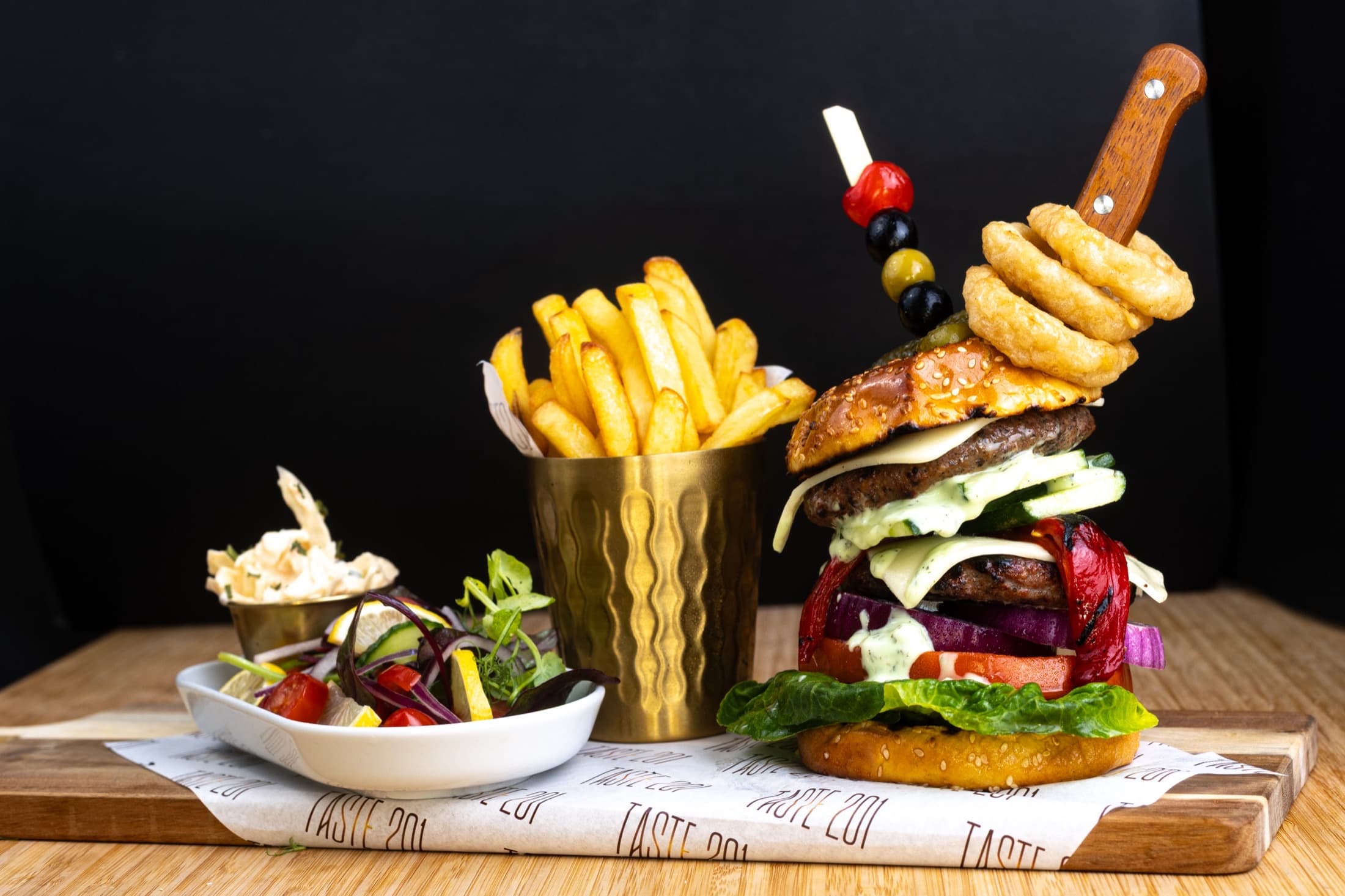 Gourmet burger with fries and side salad
